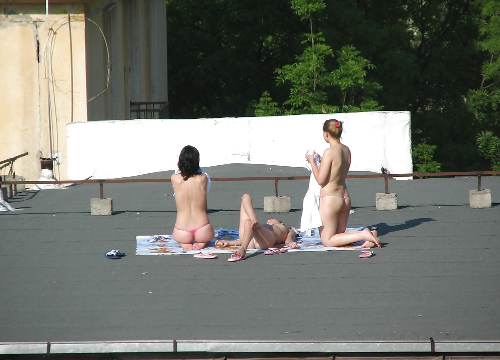 Голые девушки загорают на крыше фото