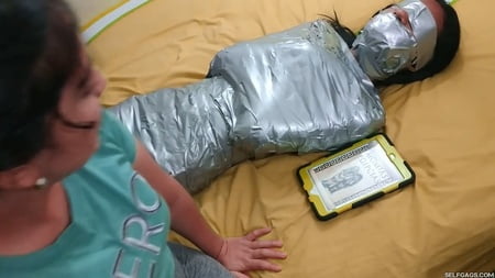 young girl duct tape wrapped like an egyptian mummy         